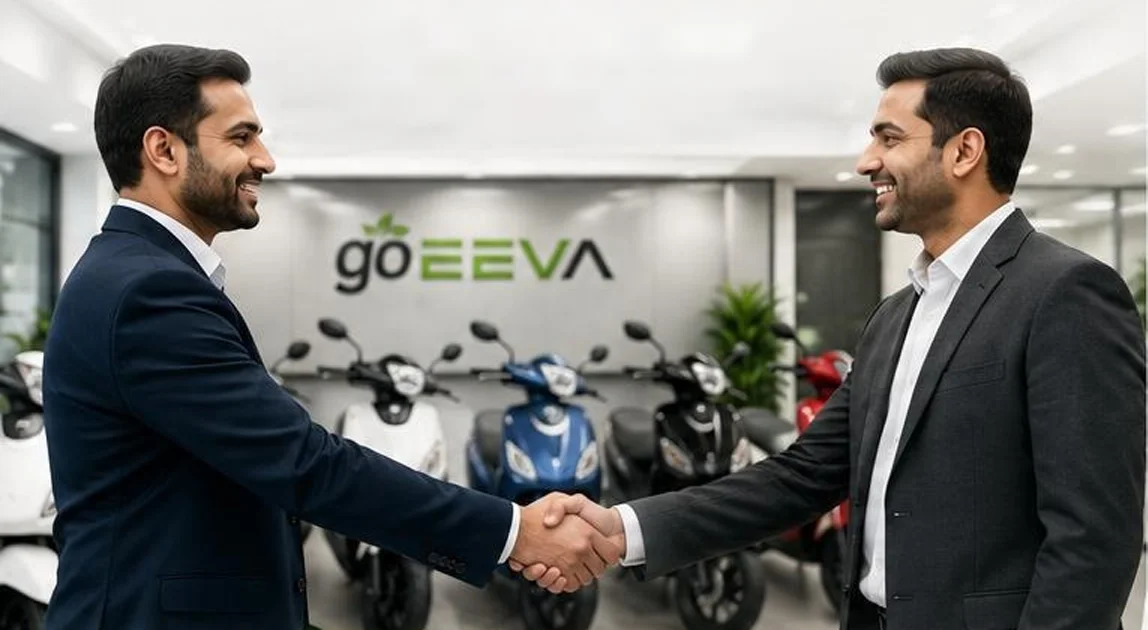 Two business partners shaking hands inside a goEEVA showroom with scooters on display